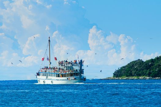 Tourists floating on white boat on the sea of Adriatic