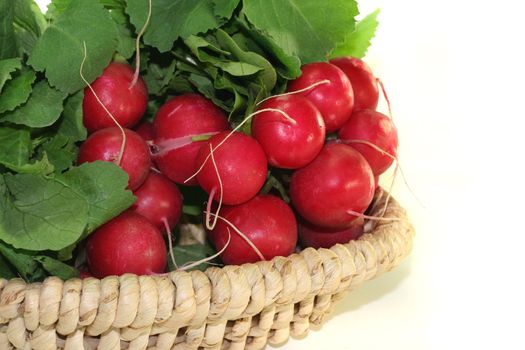 fresh radishes with green leaves in a basket