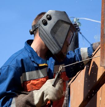 Welder wearing a mask while working outdoors