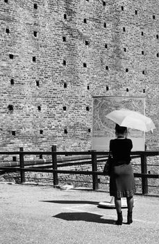 Fashionable tourist girl reading a map of town in Milan, Italy