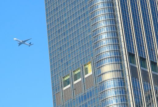 airplane fly over the modern building
