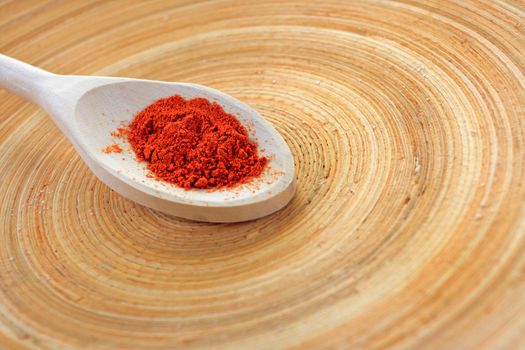 Wooden spoon of red spices on wooden plate