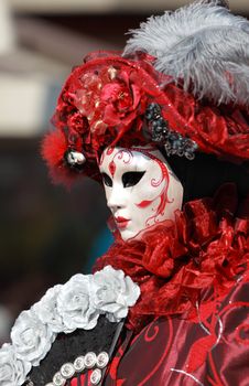 Portrait of a red Venetian mask and costume during the Carnival of Venice days.