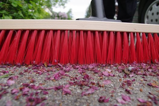 sweeping the sidewalk with a broom