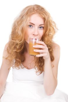 Redheaded woman drinking juice in bed
