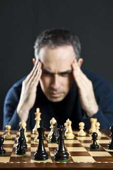 Chessboard with man thinking about chess strategy