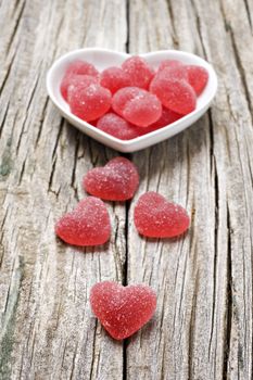 Red heart shaped jelly sweets on a rustic background