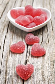 Red heart shaped jelly sweets on a rustic background