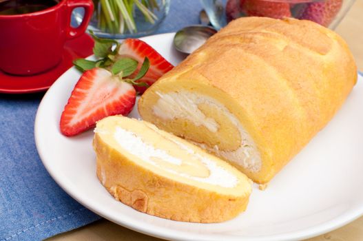 Sponge Roll With Cream and Strawberries and Coffee on Table