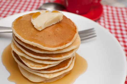 Pancakes With Butter and Warm Maple Syrup On The Table