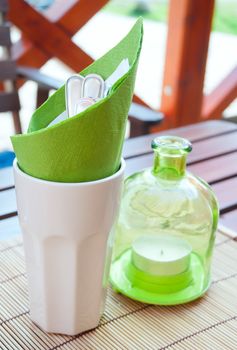 Cutlery and Candleholder on Wooden Table in Garden Restaurant