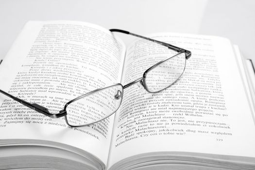 the reading glasses on a open book