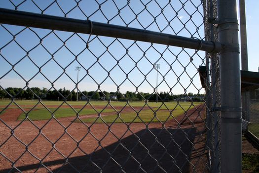 A view from behind the fence at a small baseball field.