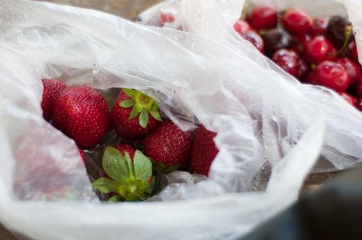 Ripe trawberry and cherry in plastic bag