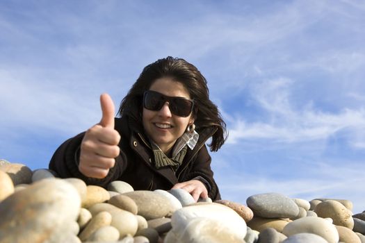 young casual woman with thumbs up in the beach