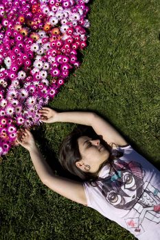 beautiful young woman in the grass with colorful flower bouquet