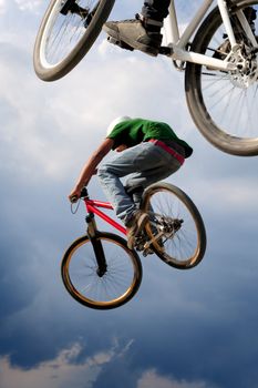 Two BMX bikers high up in the air.  Some motion blur on both bikers.
