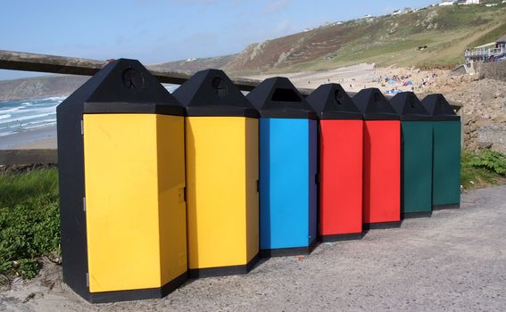 A group of different coloured trash cans