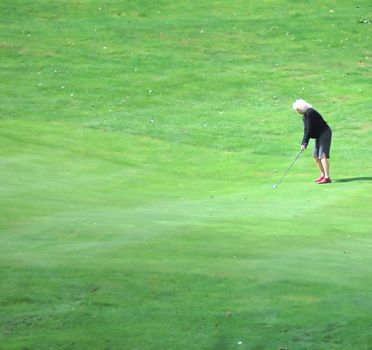 Senior woman golfer playing in a tournament.