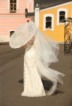 The bride with a umbrella in a sunny day