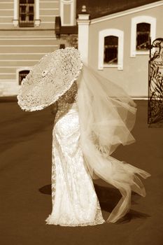 The bride with a umbrella in a sunny day. In style of a retro