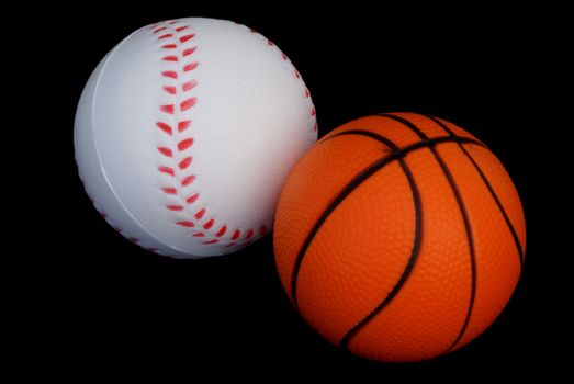 A basketball and a baseball isolated on black background.