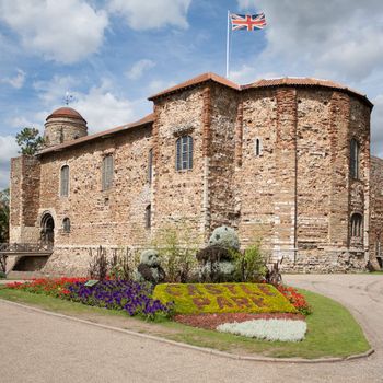 11th century Norman castle in Colchester in springtime and UK flag.