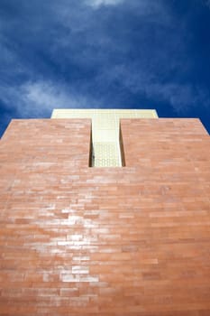 A brick tower with yellow glass at the top