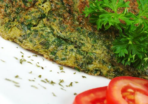 Omelette with herbs on white plate with parsley and tomato slices (Selective Focus)