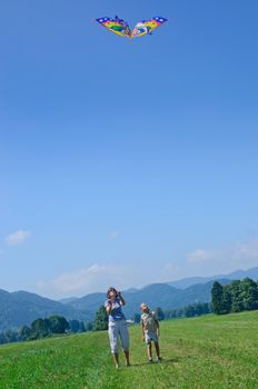 Mom and daughter play a kite in the Alps