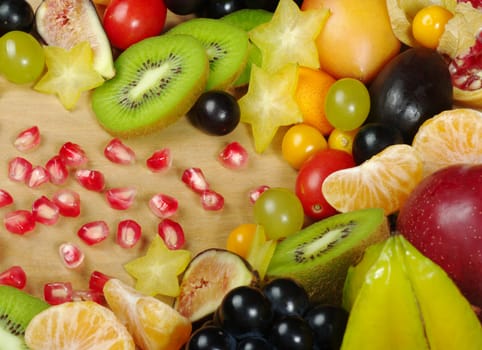 A big variety of exotic fruits on a wooden board photographed from above (Selective Focus)