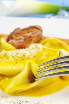 Ravioli served with meat with fork in the foreground (Selective Focus)