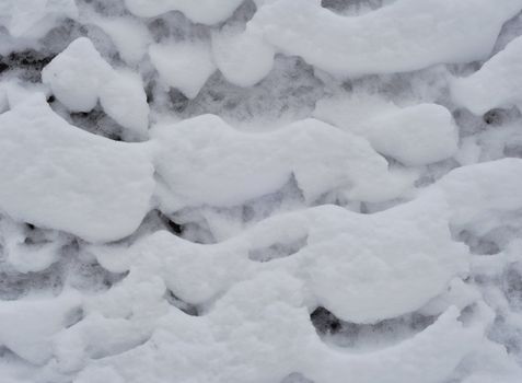 Winter natural photo: snow frozen to a wooden fence