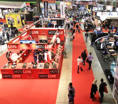 Looking at new motorcycles stands at EICMA, International Motorcycle Exhibition 2010 in Milan, Italy.