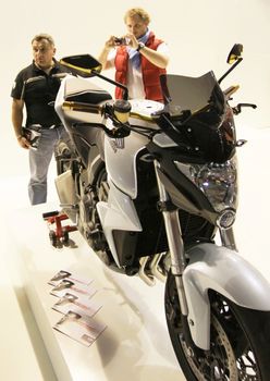 Looking at new motorcycles stands at EICMA, International Motorcycle Exhibition 2010 in Milan, Italy.