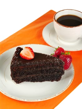 Chocolate cake with strawberries and coffee on orange mat (Selective Focus)