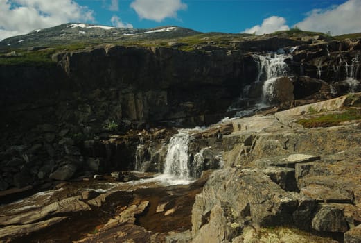 Small waterfall surrounded by rocks along the Nordkalottleden in Norway 