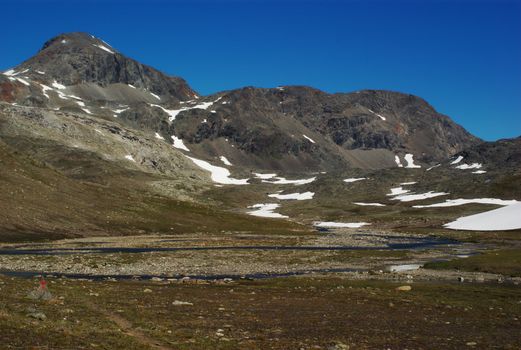 Barren mountain scenery with leftover snow along the Nordkalottleden, Norway