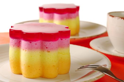 Peruvian colorful small cakes called Torta Helada in the shape of a flower with coffee and fork (Selective Focus) 