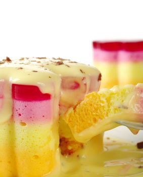 Peruvian colorful small cakes called Torta Helada in the shape of a flower with vanilla custard, chocolate shavings and a piece on a fork (Selective Focus) 