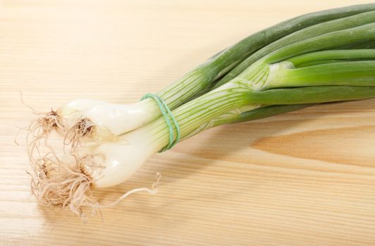 bunch of spring onions on a wooden table