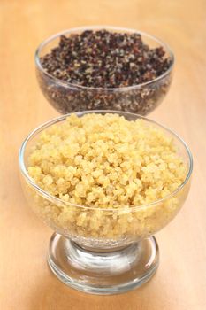 Cooked white and red quinoa in glass bowls which can be eaten as a side dish like rice and is rich in proteins (Selective Focus, Focus on the front of the white quinoa) 