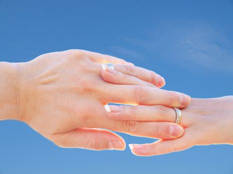 Married couple holding hands towards fresh blue sky