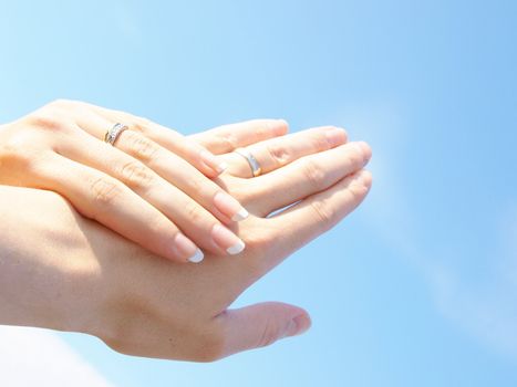 Married couple holding hands towards fresh blue sky