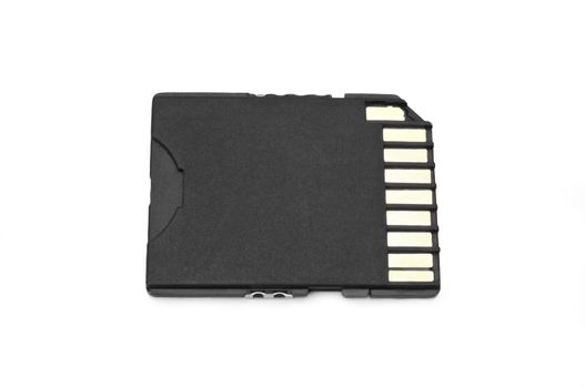 Close up on a single black SD memory card arranged over white