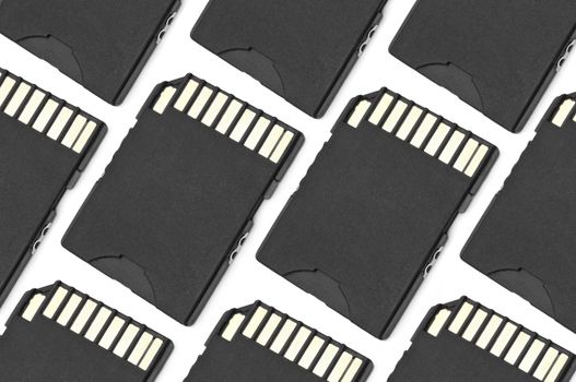 Close up on a pattern of black SD memory cards arranged over white