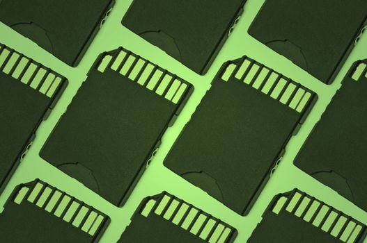 Close up on a row of black SD memory cards arranged with green filter