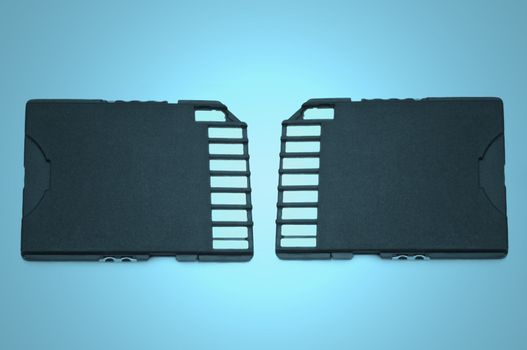 Close up on two black SD memory cards arranged over blue light filter