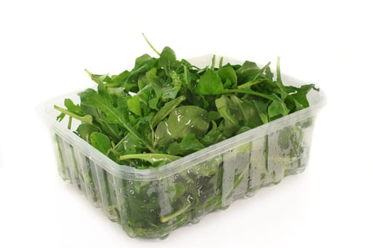 fresh rocket leaves in a transparent bowl
