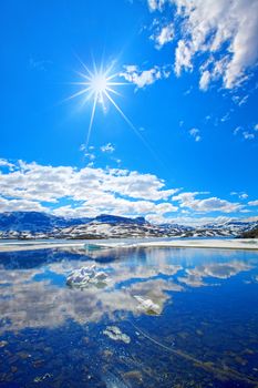 Snowcapped mountains reflecting in the water at Haukeli, Norway